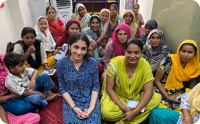 Trishha seated with women in community session
